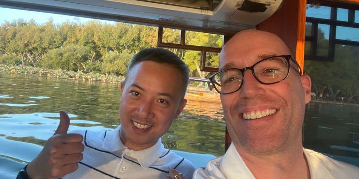 Brian and a friend on a boat at a lake