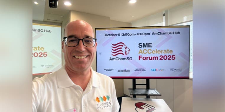 Brian in front of a screen at the AmCham event